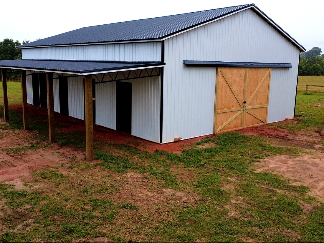 Close-up of barn sliding doors and steel trusses under the lean-to