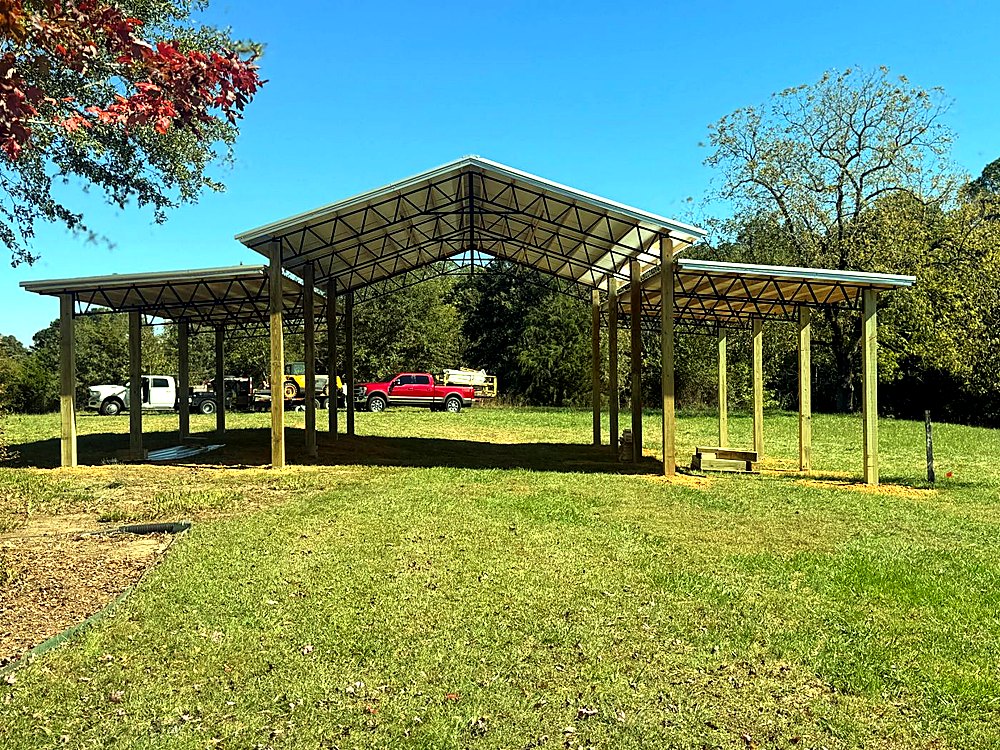 Multi-level pole barn pavilion with a raised center gable and two lean-to wings